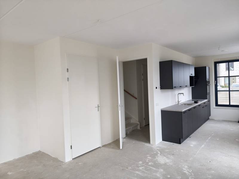 Woonkamer en keuken in nieuwbouwwoning na renovlies en sauswerk
