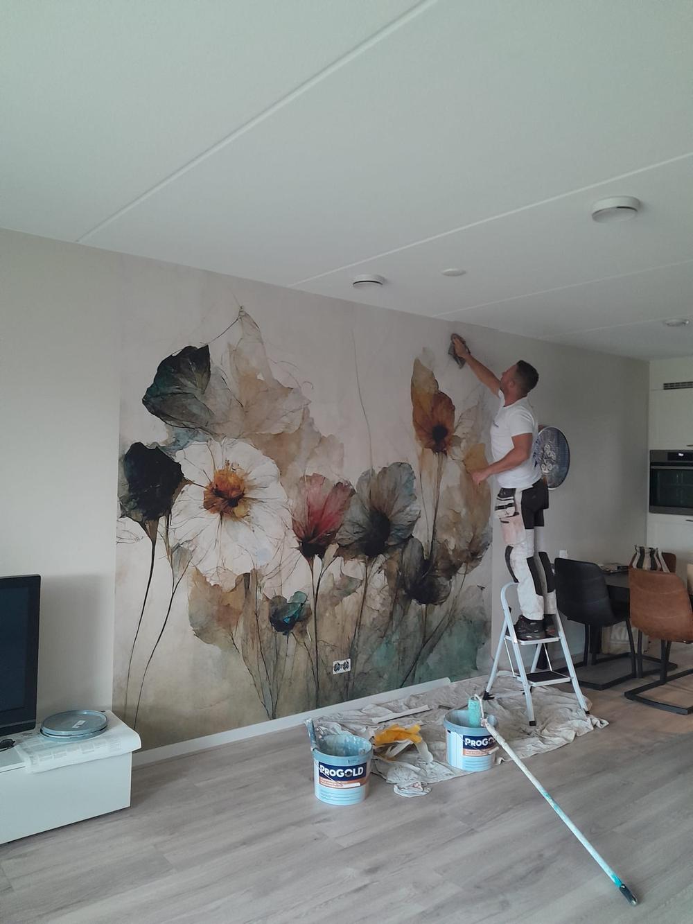 Stefan Bouwer brengt fotobehang aan in een woning in Almere